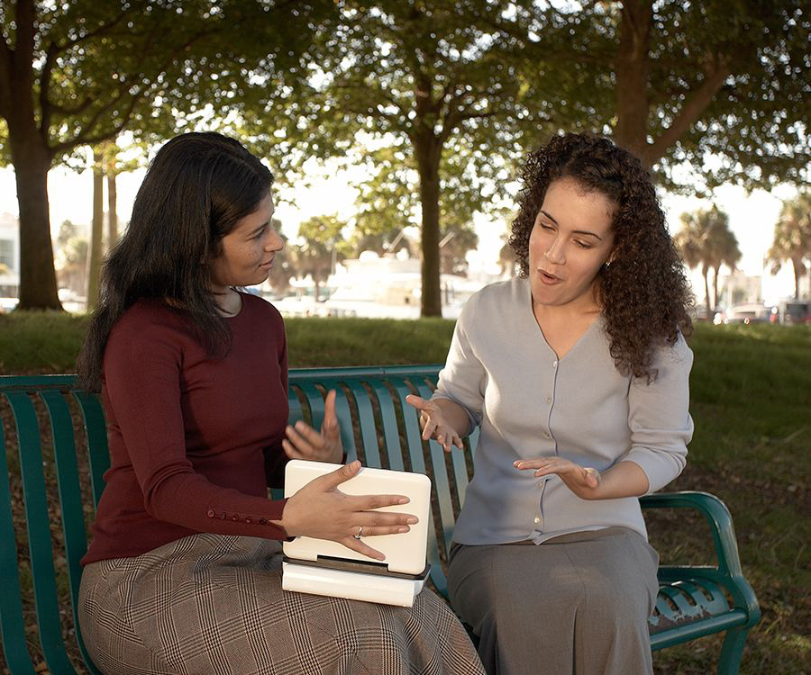 Una testigo de Jehová le lee un texto de la Biblia a una mujer