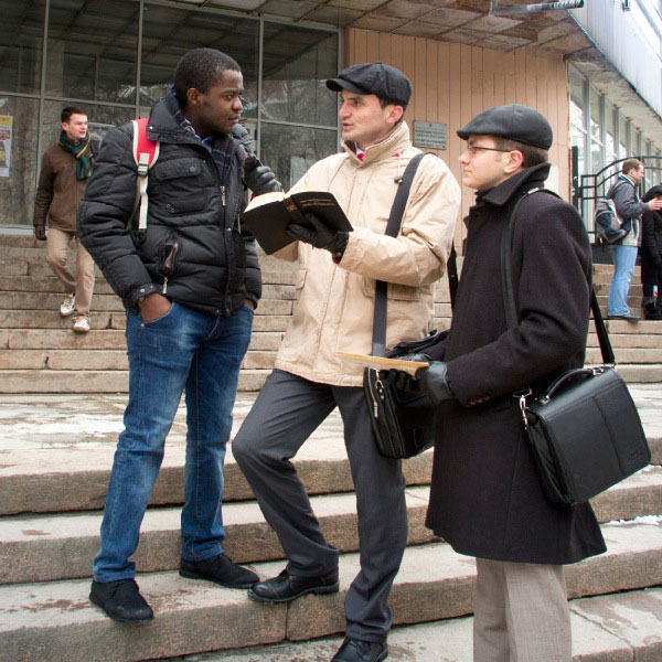 Testigos de Jehová predicándole a un hombre