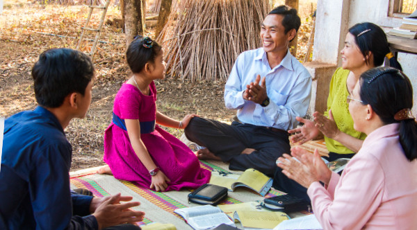 Un padre estudia la Biblia con su familia