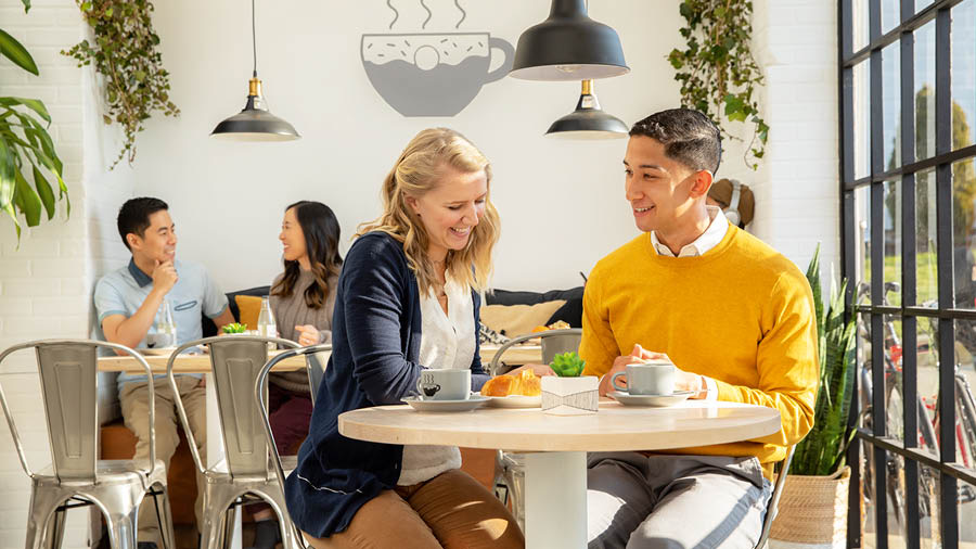 Una pareja conversa feliz en una cafetería.