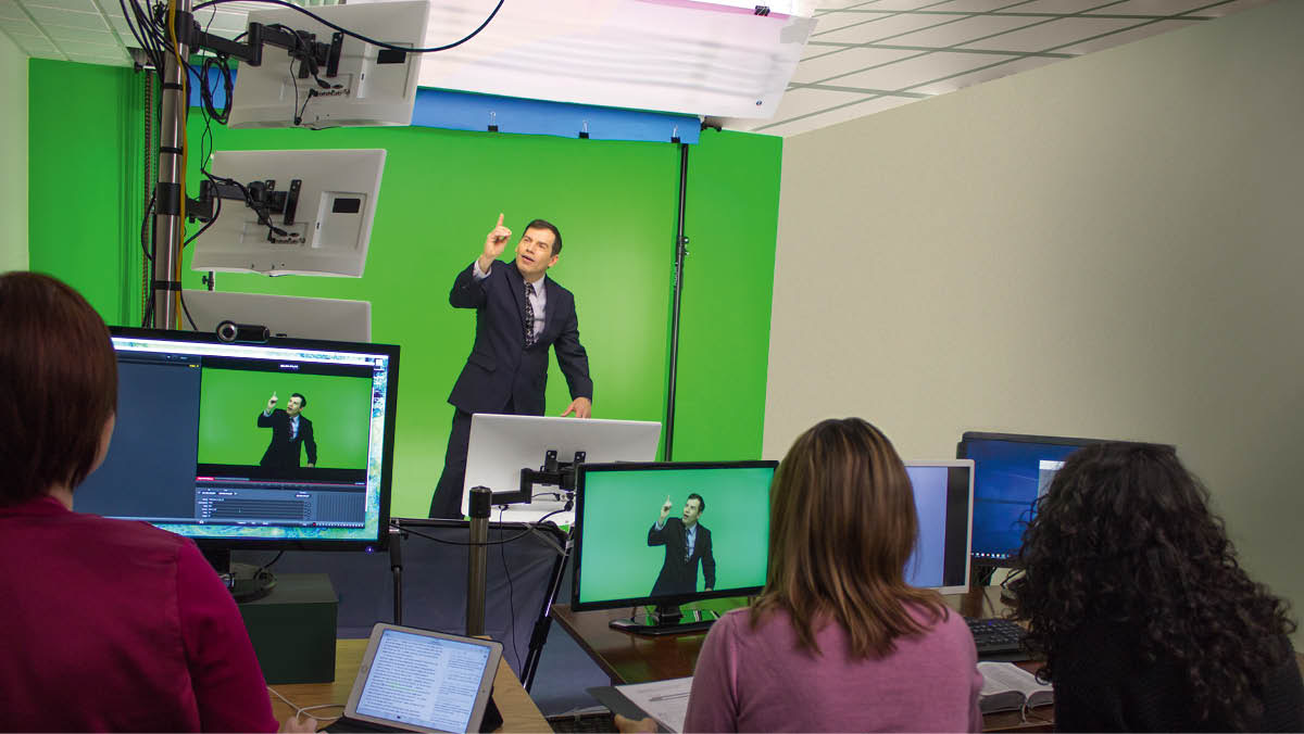 ’n Vertaalspan wat ’n gebaretaalpublikasie opneem. Die vertaler staan voor ’n “green screen”.