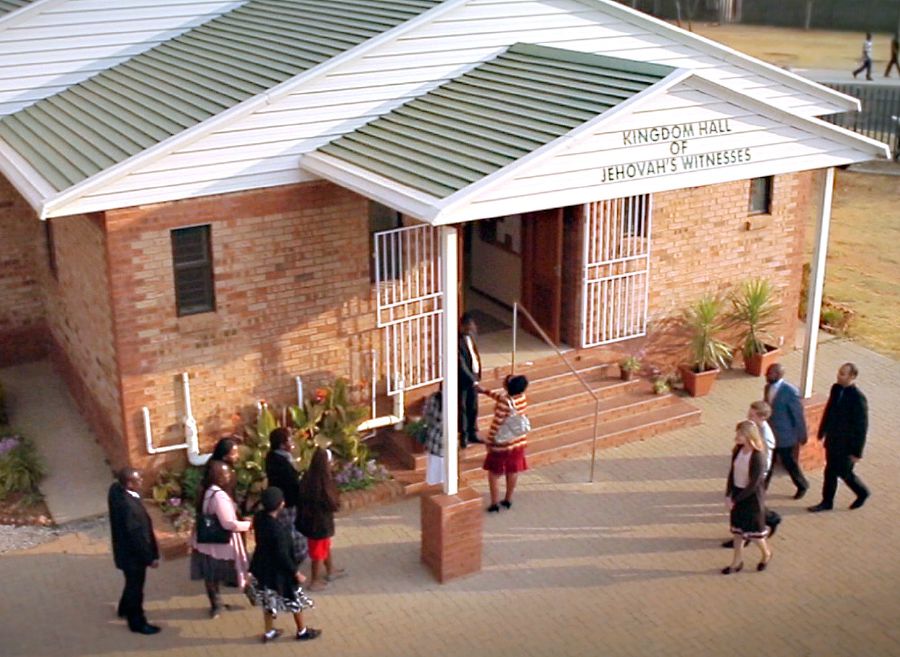 Jehovah se Getuies gaan by ’n Koninkryksaal in