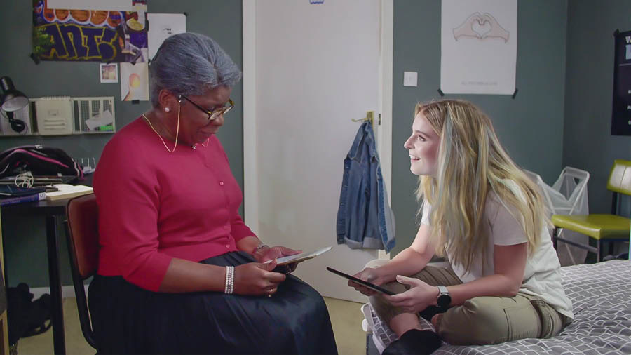 ’n Toneel uit die video “Ervaar die vreugde van die dissipelmaakwerk – Aanvaar Jehovah se hulp – Ons broers”. Abigay studeer die Bybel met Jade terwyl Neeta weg is.