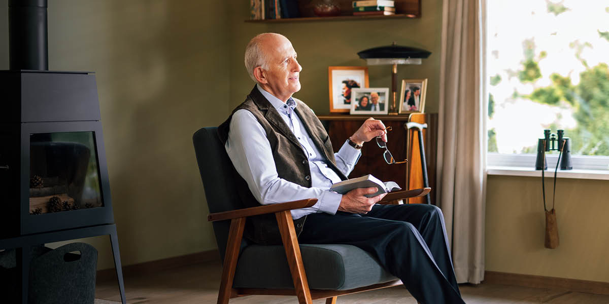 ’n Bejaarde man dink na oor wat hy in die Bybel lees.