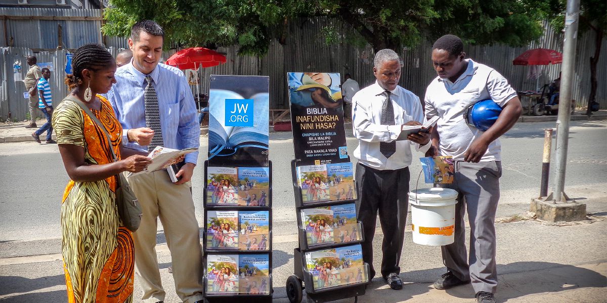 Jehovah se Getuies staan langs lektuurstaanders en preek vir mense in Dar es Salaam, Tanzanië