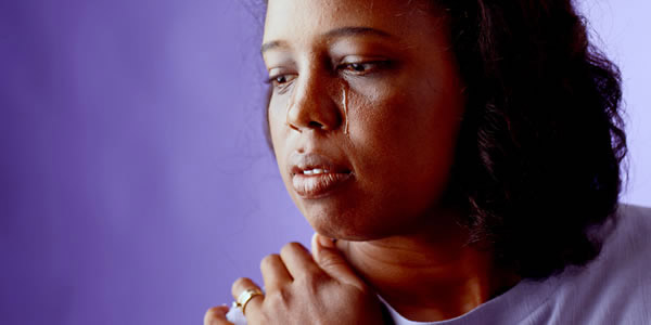 በሐዘን ተውጣ እያለቀሰች ያለች ሴት።