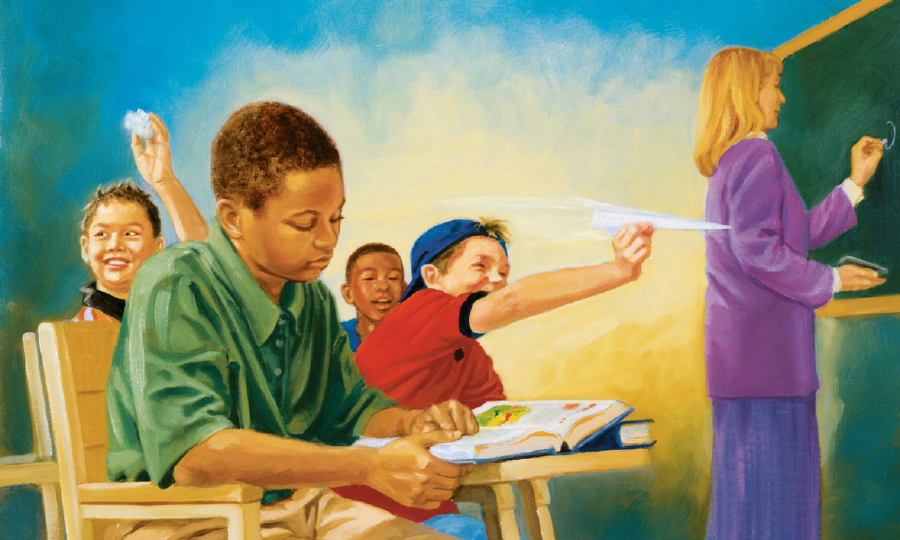 صبي يركِّز في الصف فيما يتصرف رفاقه بقلة تهذيب