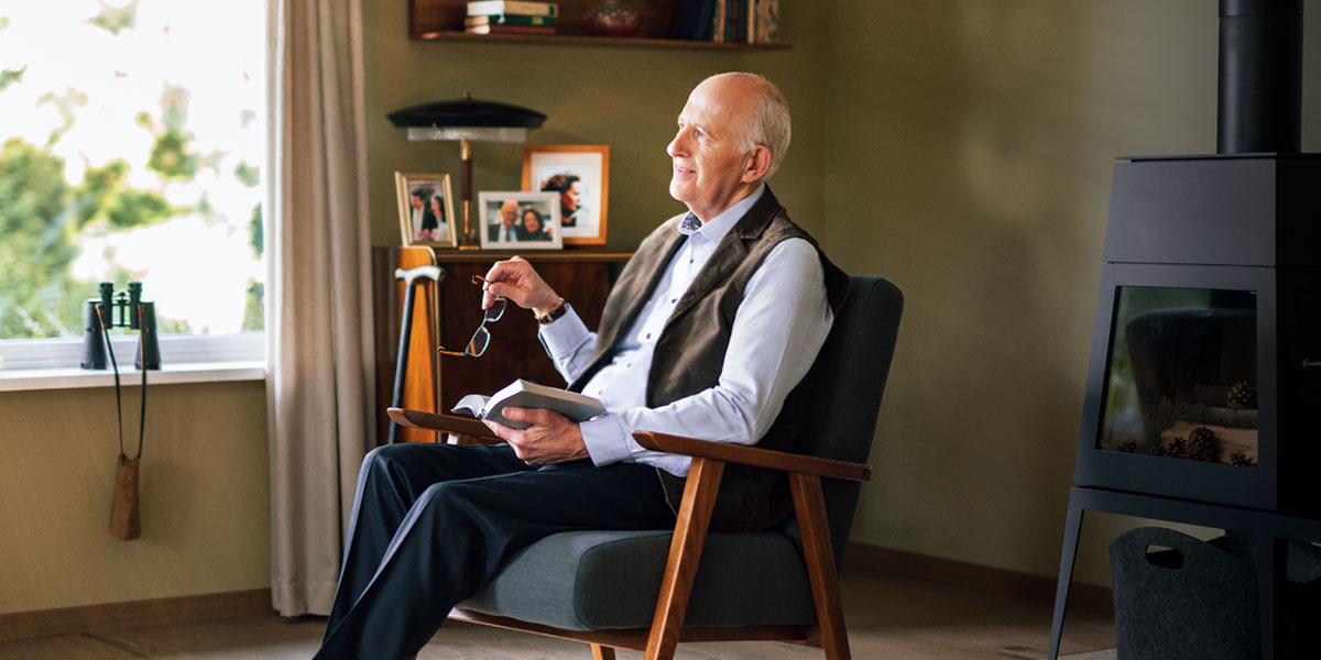 رجل كبير في العمر يفكر في ما يقرأه من الكتاب المقدس