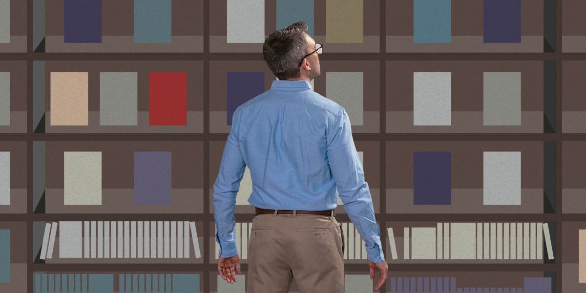 A man looks up at shelves full of books