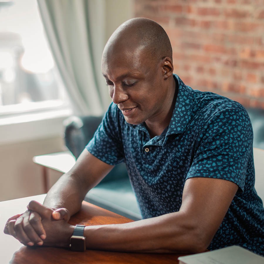 The man is praying before reading the Bible.