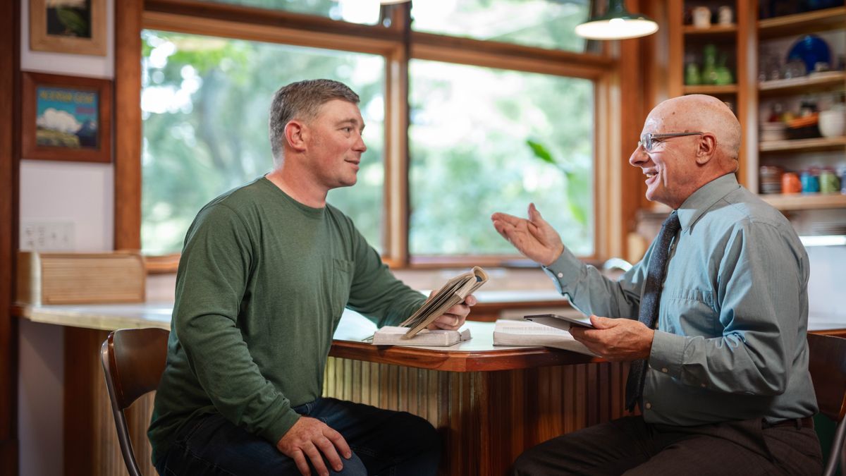 Un frère d’âge mûr rend visite à un autre frère et l’encourage à l’aide de la Bible.