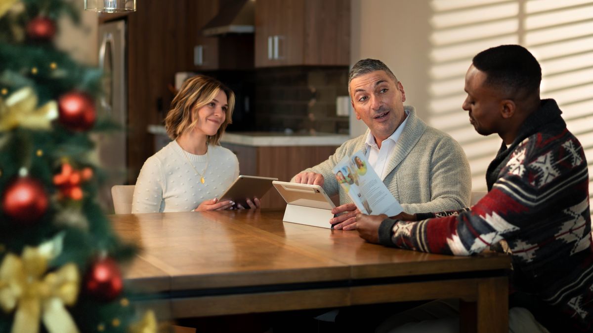 Le couple de l’illustration précédente est chez l’homme à qui ils avaient prêché. Ils lui donnent un cours biblique à l’aide de la brochure « Vivez pour toujours ! ». L’arbre de Noël est dans la pièce.