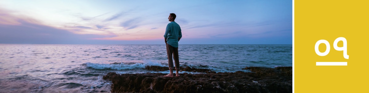 পাঠ ৭. একজন ব্যক্তি সূর্যাস্তের পর সমুদ্রের ধারে পাথরের উপর দাঁড়িয়ে আছেন এবং সমুদ্রের দিকে তাকিয়ে আছেন।