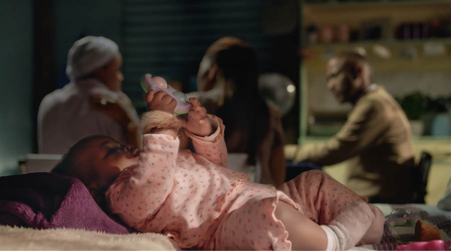 En pti baba pe alonze lo lili avek en brasle portboner dan son lanmen. Son manman ki pe etidye Labib pe koz avek sa koup ki fer son letid.