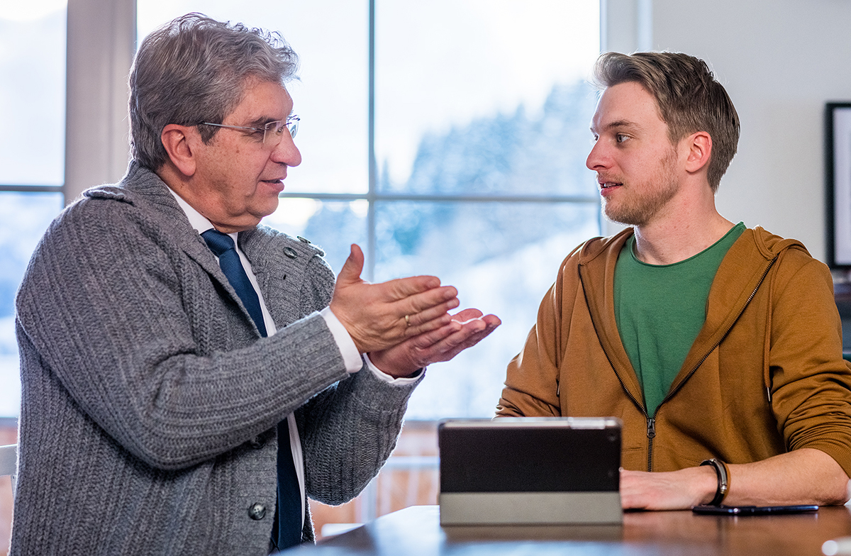 一个弟兄用手机播放短片给学生看。