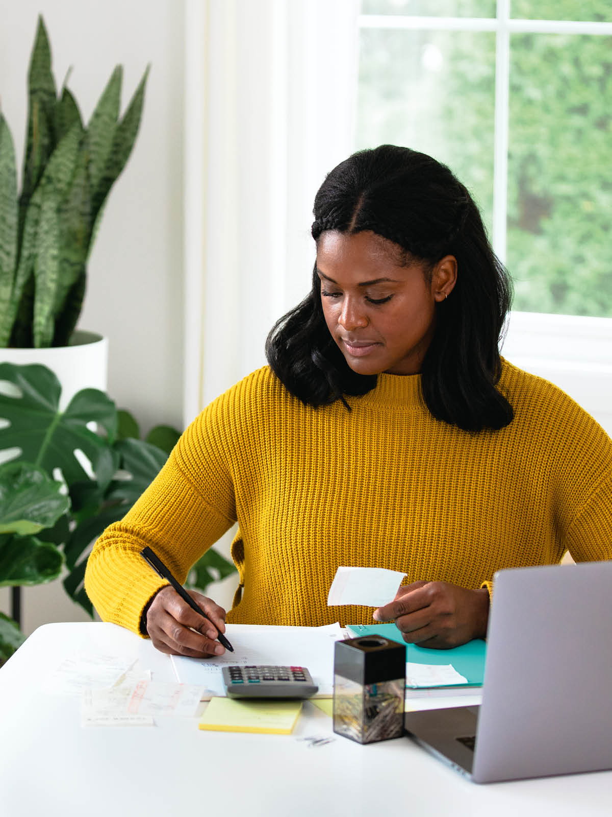 En kvinde taster nogle tal fra en kvittering ind på sin lommeregner.