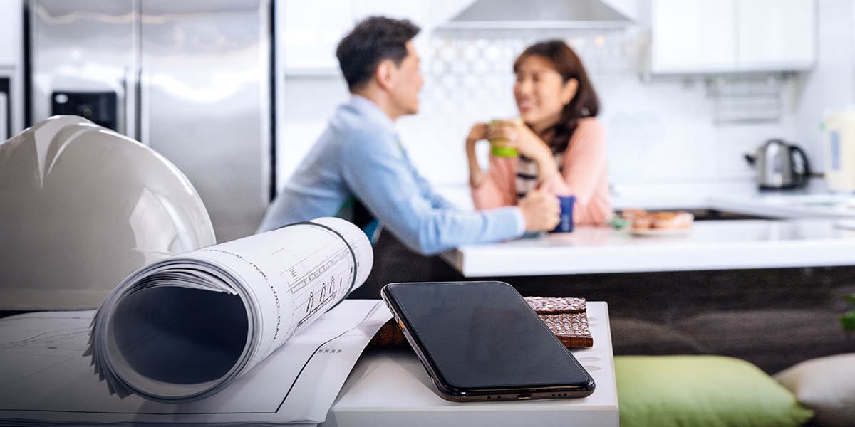 En mand og hustru drikker kaffe sammen i deres køkken. De har lagt deres arbejde og telefoner væk.