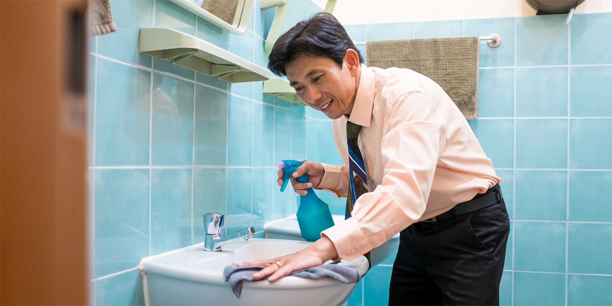 En bror gør rent på et toilet i rigssalen