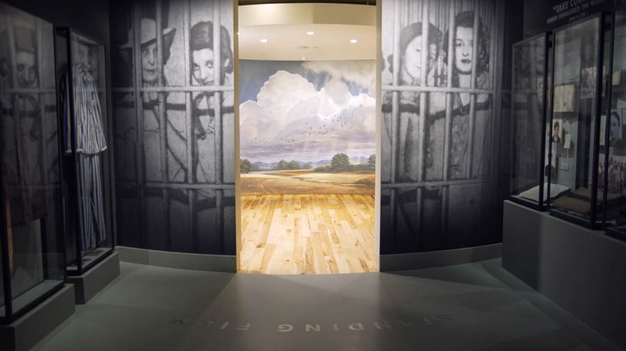 Et billedgalleri på et museum viser hvor mange der blev fængslet for deres tro. Dørene er åbne ind til et rum der viser et glimt af paradiset.