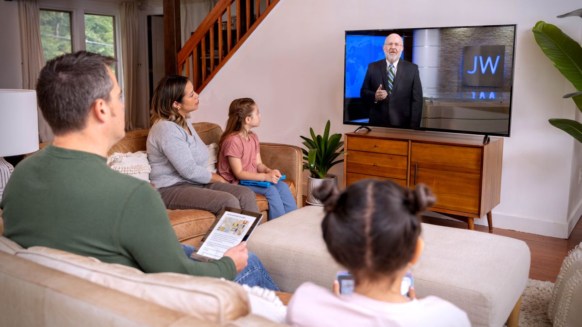 En familie ser et program på JW Broadcasting.