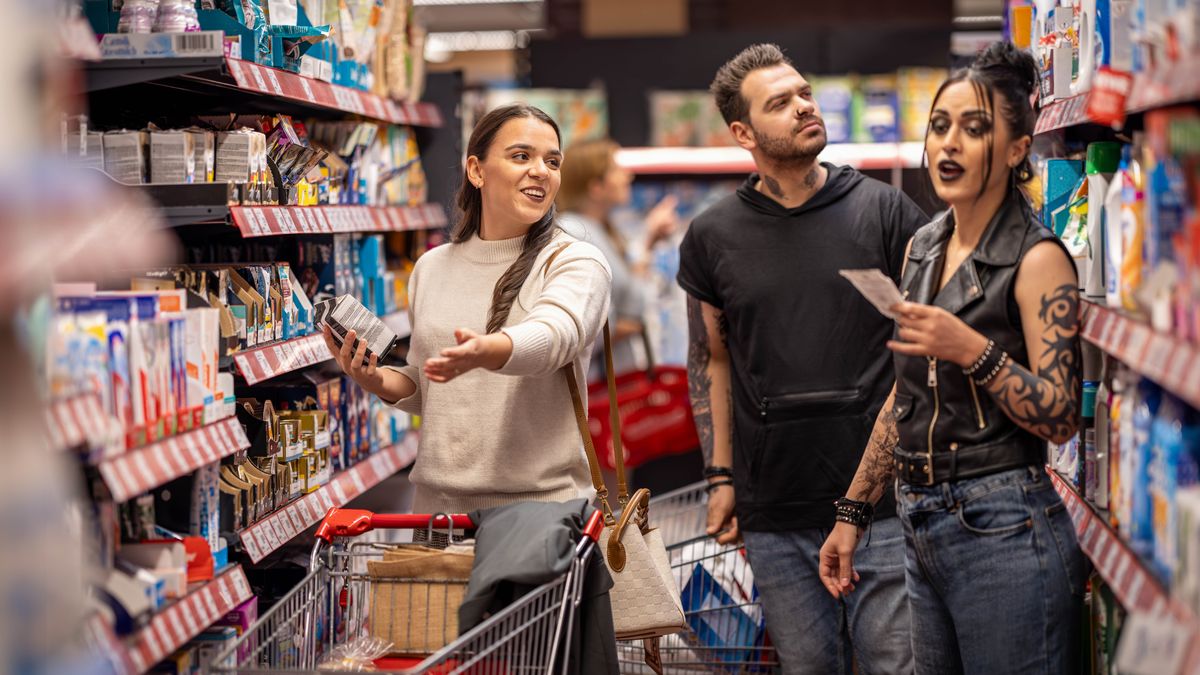 En kvinde hjælper et par med at finde noget de leder efter, i et supermarked. Hun behandler dem venligt selvom de ser anderledes ud og har mange tatoveringer.