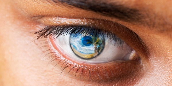 Ein Paradiesbild spiegelt sich in der Iris eines menschlichen Auges