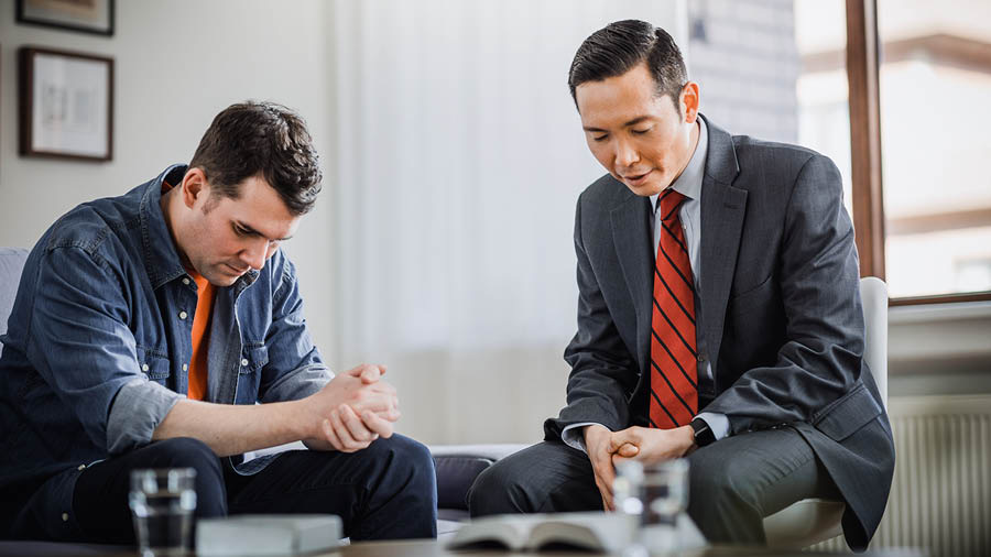 Ein Ältester betet mit einem Bruder, der zu Jehova zurückgekehrt ist.