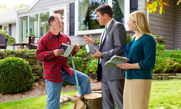 Jehovah’s Witnesses talking to a man who is chopping wood