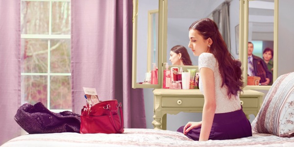 Parents look on as their teenage daughter stares at her Watchtower magazine