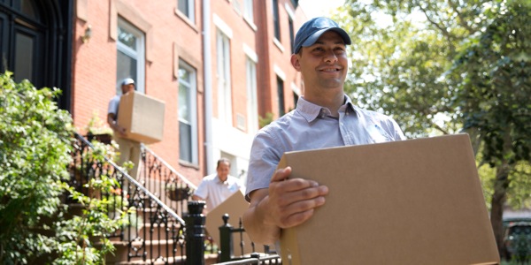 A young man on a moving crew enjoying his work