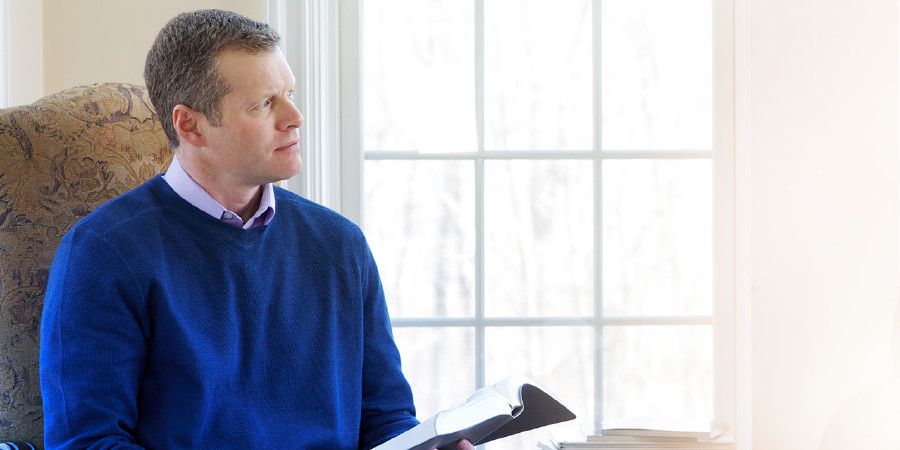 A man meditates as he reads the Bible