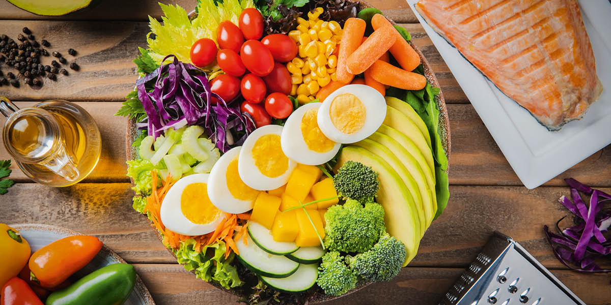 En una mesa, hay muchos alimentos saludables.