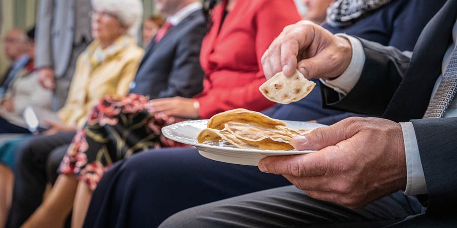 Un hermano ungido tomando un trozo del pan de la Conmemoración.