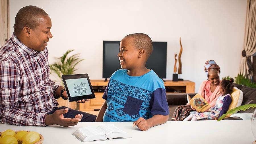 Unos padres estudian la Biblia por separado con sus hijos
