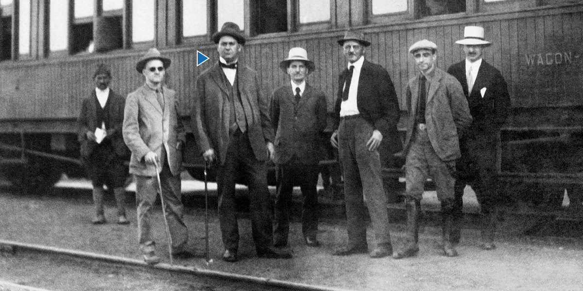 Joseph Rutherford junto a un tren con otros hermanos.