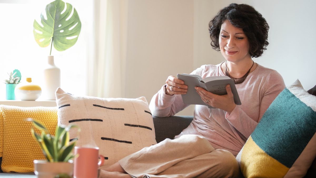 Una hermana en su casa leyendo la Biblia.