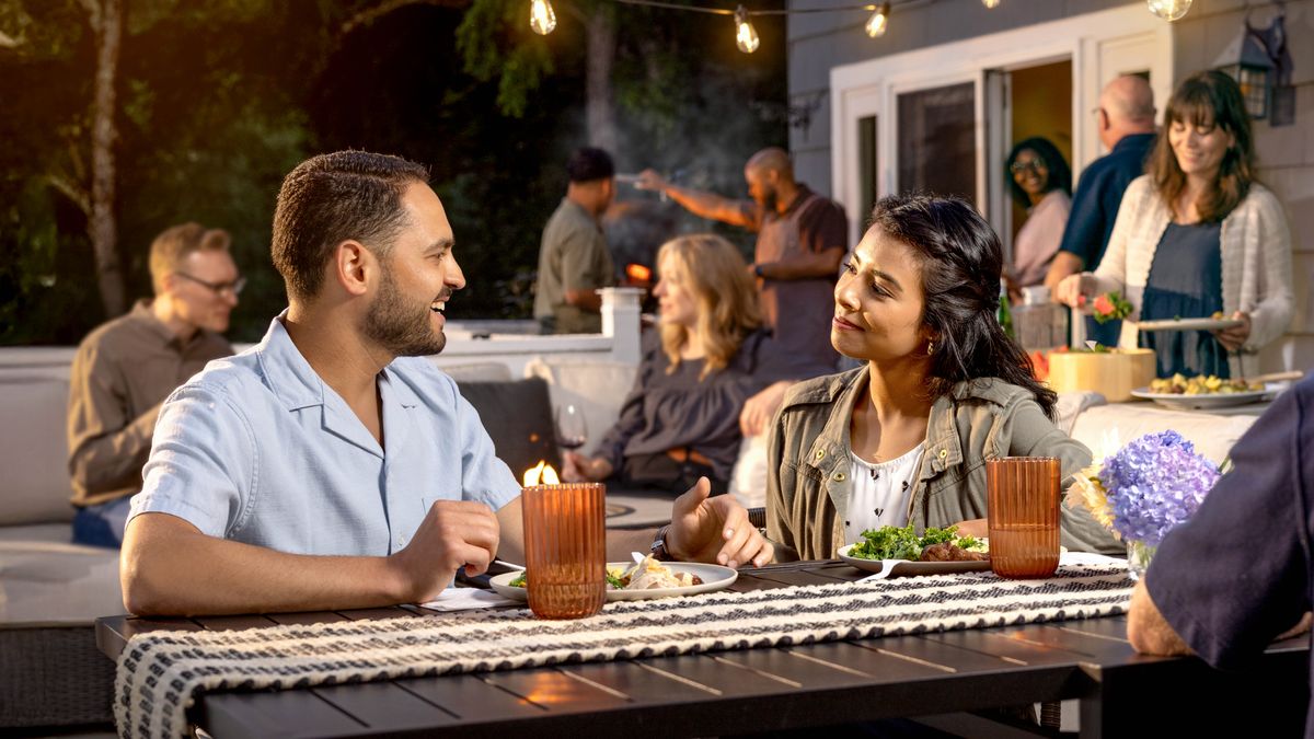 Una pareja de novios disfrutando de una agradable conversación durante una reunión social con amigos.