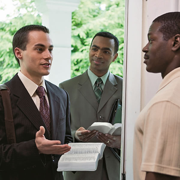 A Bible student along with his teacher in the public ministry, sharing the good news with a man