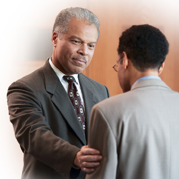 An elder warmly welcoming a brother who has approached him.