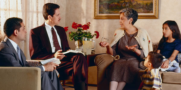 Two elders visiting a sister and her two children at her home. They listen intently as she speaks.