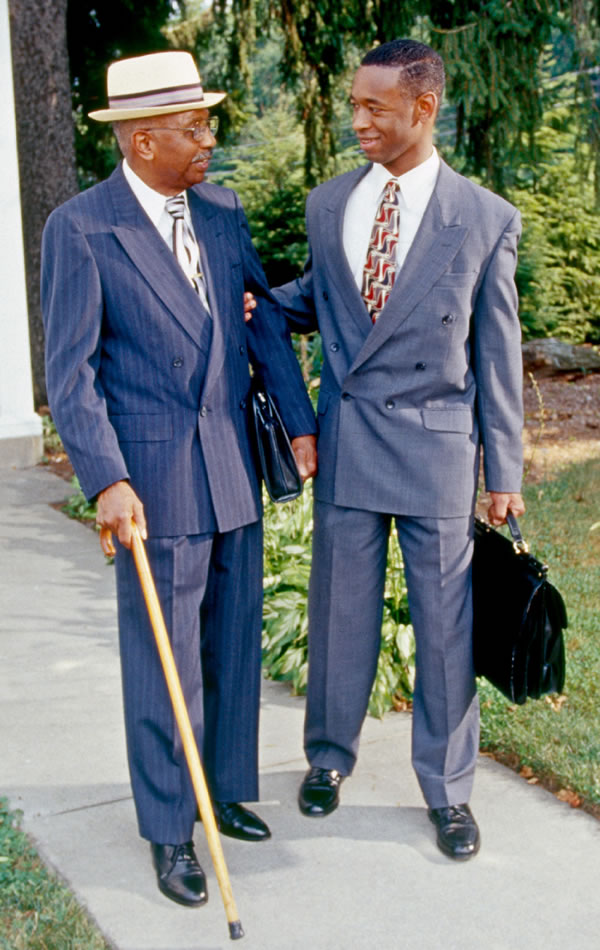 A young brother happily assisting an elderly brother in the ministry.