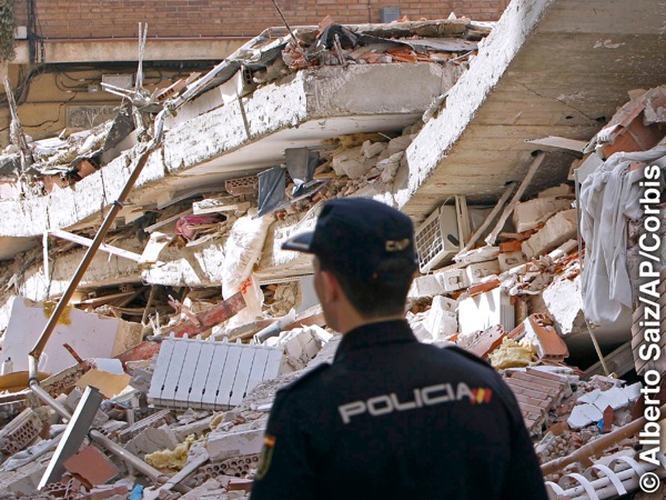 A rescue worker viewing buildings destroyed by an earthquake
