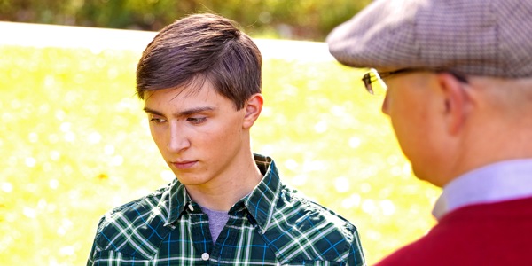A young man receiving correction from an older man