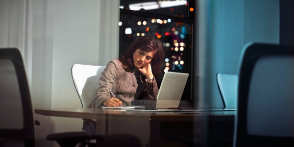A stressed woman working overtime
