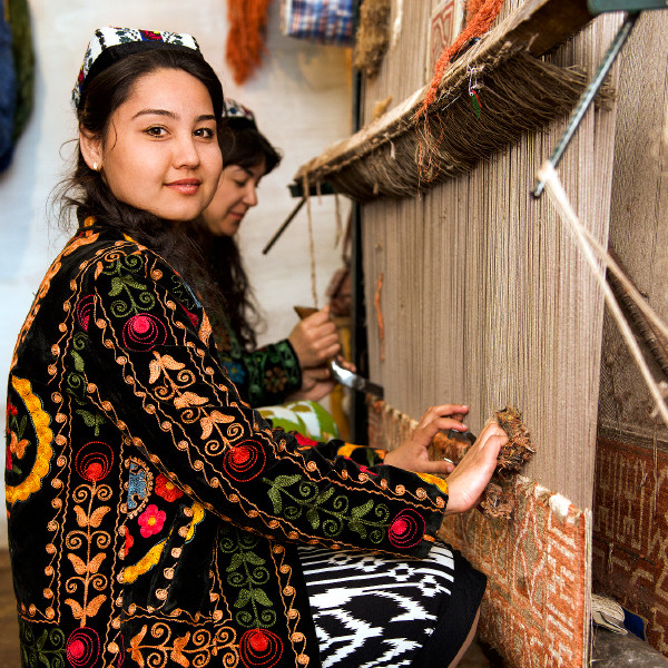 Two Uzbek women make silk carpets