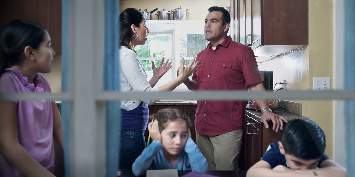 Distraught children listen to their parents argue