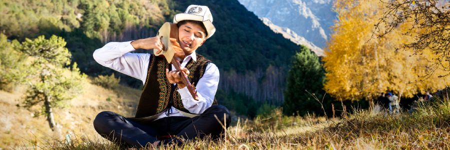 A young man plays the komuz