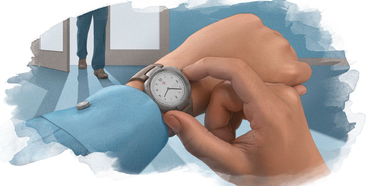 A man checks the time on his watch as another man enters the room