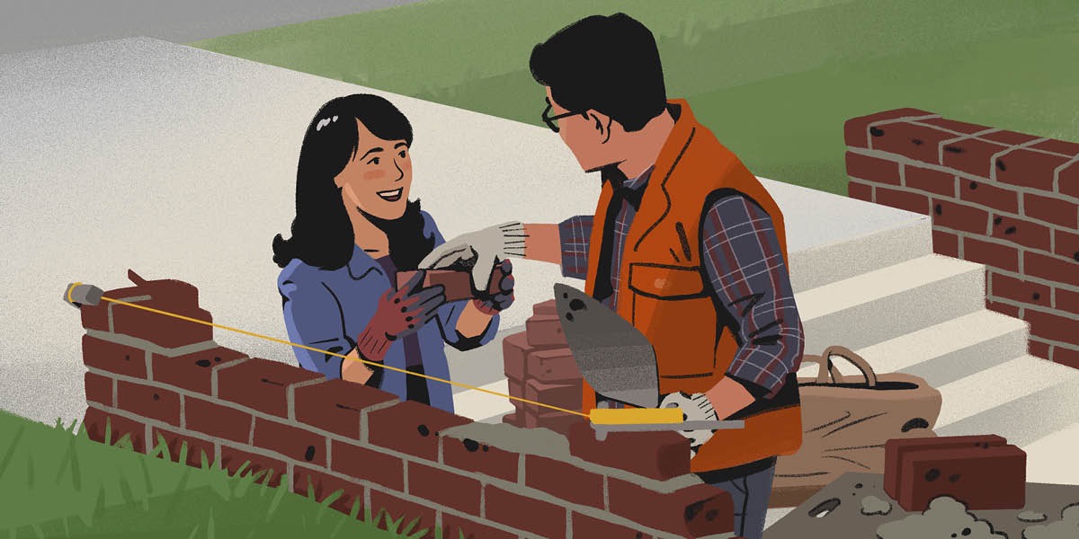 A couple uses mortar to lay bricks