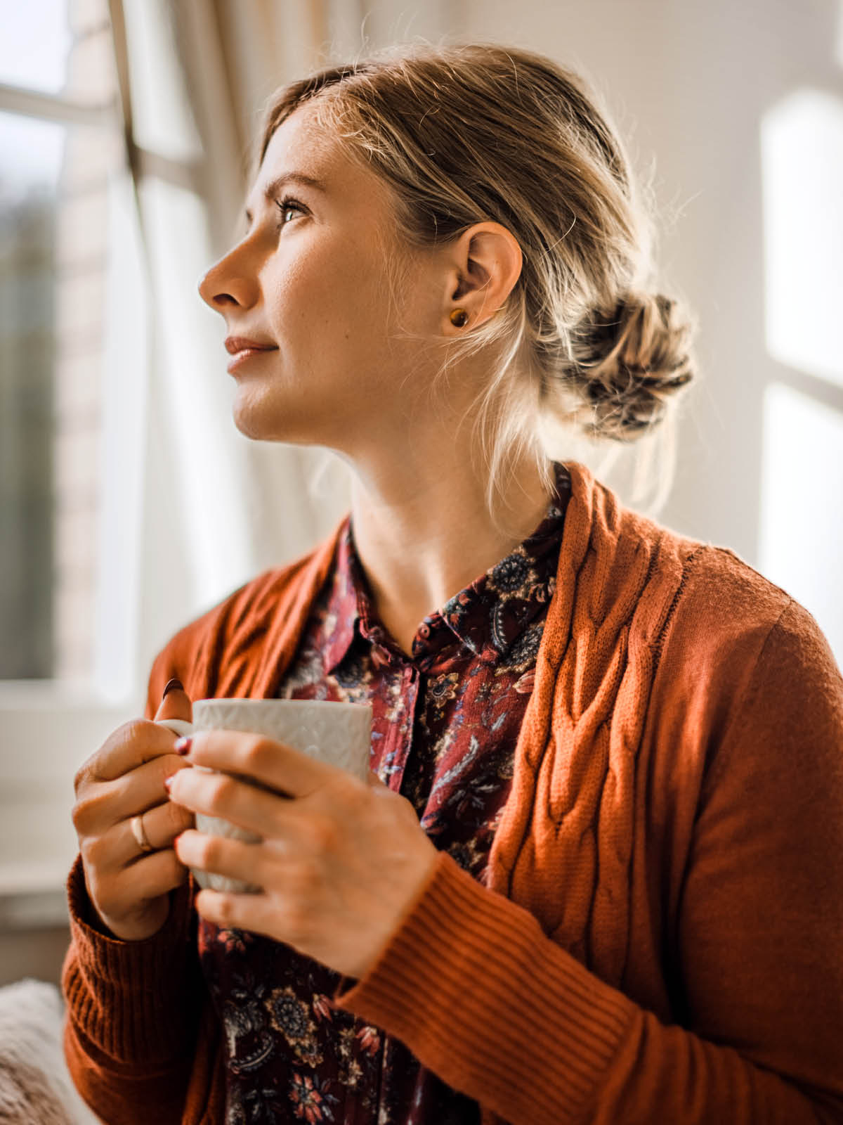 A woman gazing contentedly out a window.